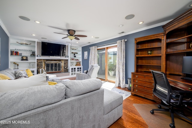 9 Partridge Ave, Freehold, NJ 07728 - living area with ornamental molding, a desk, a ceiling fan, wood finished floors, and a fireplace
