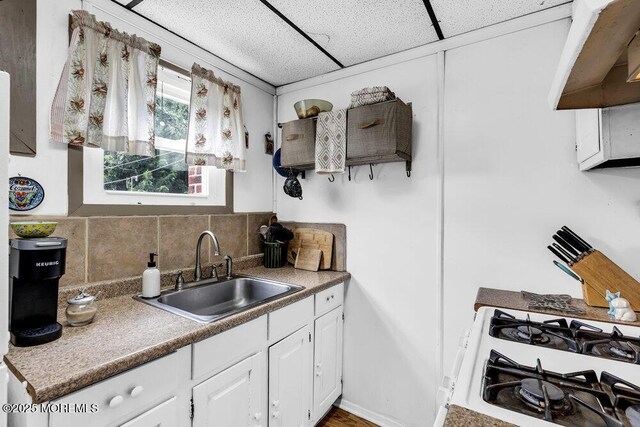 194 Washington St, Keyport, NJ 07735 - kitchen with white cabinets, tasteful backsplash, white range with gas stovetop, and a paneled ceiling