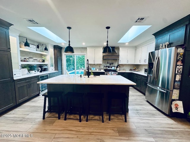 412 Steuben Ave, Forked River, NJ 08731 - kitchen featuring a skylight, appliances with stainless steel finishes, wine cooler, light stone countertops, and recessed lighting