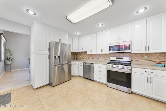 1 Spruce Way, Manalapan, NJ 07726 - kitchen with appliances with stainless steel finishes, light countertops, tasteful backsplash, light tile patterned flooring, and white cabinetry