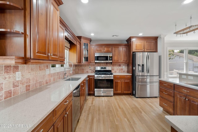6 Frances Ct, Red Bank, NJ 07701 - kitchen featuring appliances with stainless steel finishes, open shelves, brown cabinetry, light wood finished floors, and light stone countertops