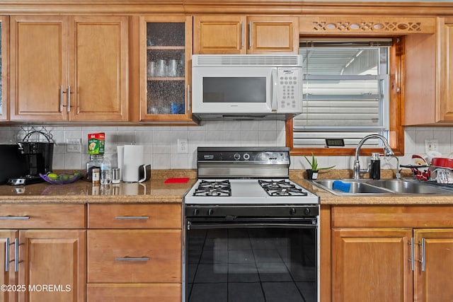 612 Grier Ave, Elizabeth, NJ 07202 - kitchen featuring white microwave, range with gas stovetop, tile patterned flooring, glass insert cabinets, and backsplash