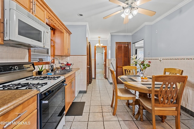 612 Grier Ave, Elizabeth, NJ 07202 - kitchen featuring gas range, white microwave, tile walls, light tile patterned floors, and crown molding