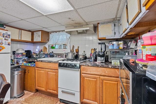 612 Grier Ave, Elizabeth, NJ 07202 - kitchen featuring white appliances, under cabinet range hood, a paneled ceiling, brown cabinetry, and tasteful backsplash