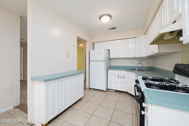 7 Kathy Ct Unit 6204, Brick, NJ 08724 - kitchen with gas stove, freestanding refrigerator, under cabinet range hood, white cabinets, and light tile patterned floors