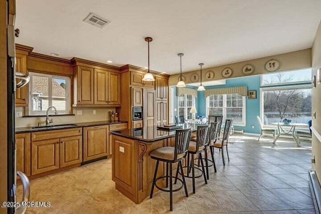 45 Leighton Ln, Manchester, NJ 08759 - kitchen with brown cabinetry, a kitchen breakfast bar, dark countertops, and a center island