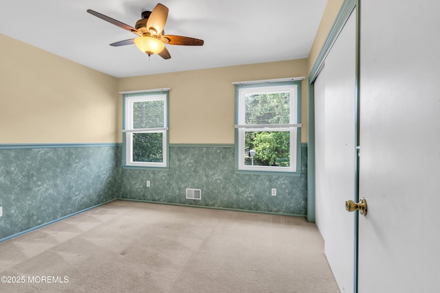 1 Denise Ct, Tinton Falls, NJ 07753 - carpeted empty room with a wainscoted wall, healthy amount of natural light, and a ceiling fan