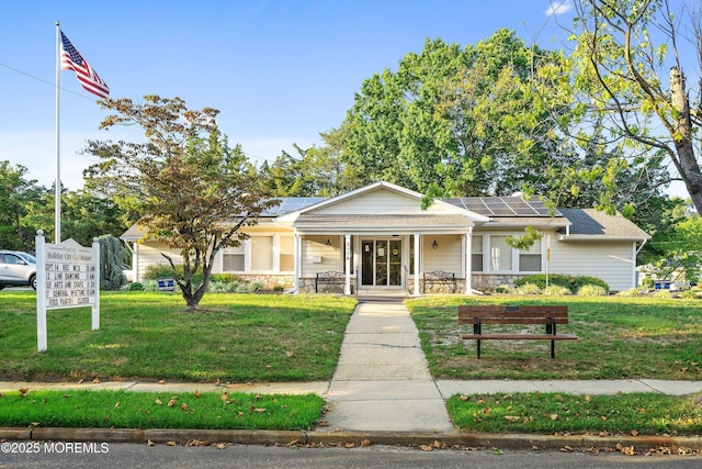 7 Bear Mountain Ct, Toms River, NJ 08753 - view of front of house with covered porch, roof mounted solar panels, a front yard, and stone siding