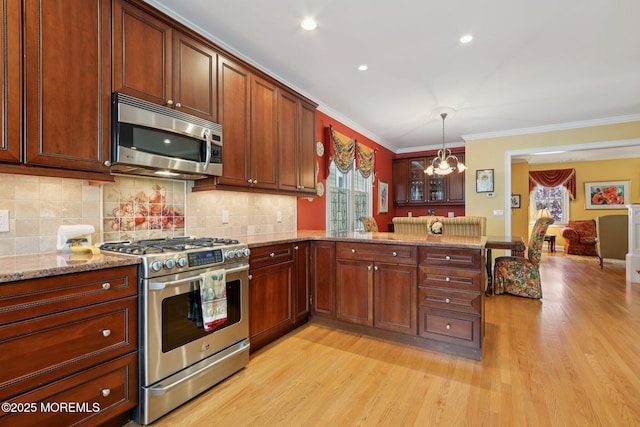 73 Clark Ave, Ocean Grove, NJ 07756 - kitchen featuring stainless steel appliances, a chandelier, light wood finished floors, ornamental molding, and a peninsula