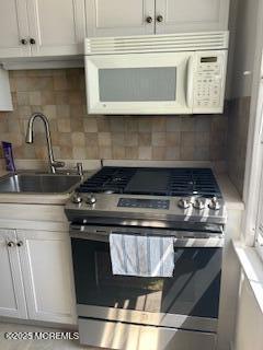 26 Pinckney Rd Unit C, Red Bank, NJ 07701 - kitchen featuring stainless steel range with gas cooktop, white microwave, decorative backsplash, and light countertops