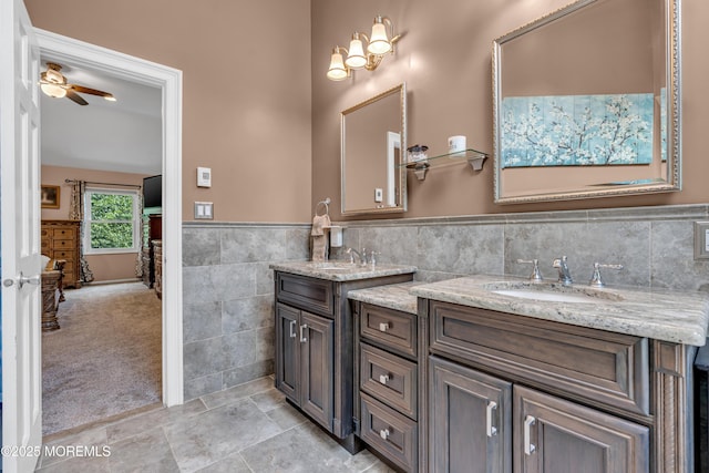 3 Algonquin Ct, Freehold, NJ 07728 - bathroom featuring tile walls, double vanity, a ceiling fan, a wainscoted wall, and tile patterned flooring