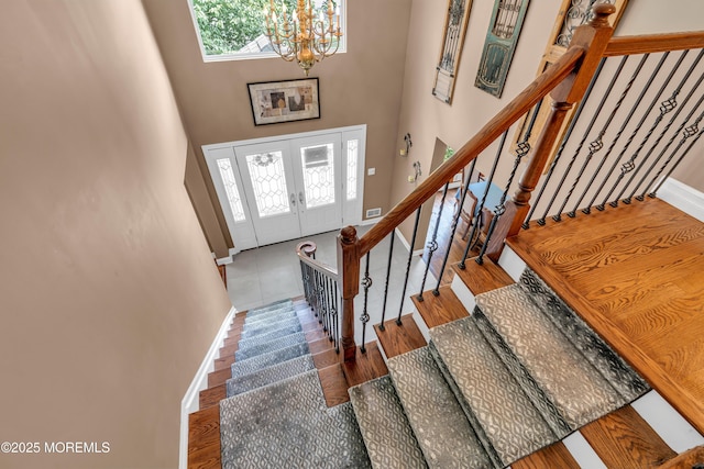3 Algonquin Ct, Freehold, NJ 07728 - stairway with a chandelier, wood finished floors, a high ceiling, and french doors