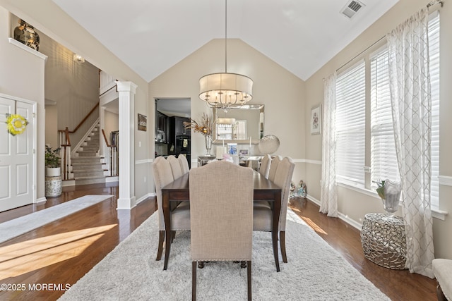 78 Honeysuckle Dr, Manahawkin, NJ 08050 - dining room featuring dark wood-style flooring, a chandelier, vaulted ceiling, stairway, and decorative columns