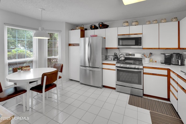186 Snow Drop Pl, Freehold, NJ 07728 - kitchen with stainless steel appliances, light countertops, hanging light fixtures, a textured ceiling, and light tile patterned flooring