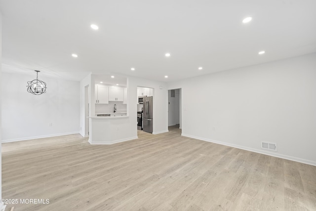 410 Owls Nest Ct, Jackson, NJ 08527 - unfurnished living room featuring recessed lighting, light wood-style flooring, and a chandelier