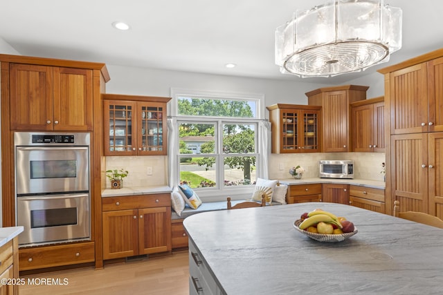 11 Sharon Dr, Ocean Twp, NJ 07712 - kitchen featuring stainless steel appliances, light wood finished floors, recessed lighting, decorative backsplash, and brown cabinets