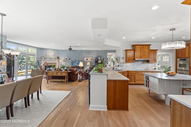 11 Sharon Dr, Ocean Twp, NJ 07712 - kitchen with brown cabinets, a peninsula, recessed lighting, light wood-type flooring, and decorative light fixtures