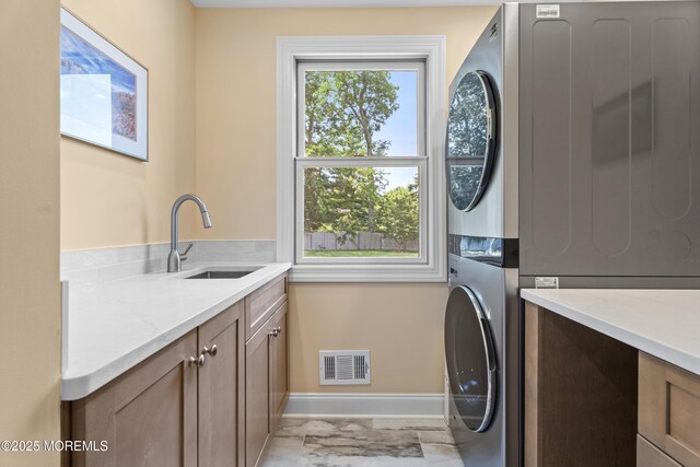 11 Sharon Dr, Ocean Twp, NJ 07712 - laundry area with cabinet space, stacked washer / dryer, and light marble finish floors