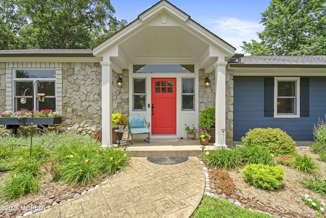 11 Sharon Dr, Ocean Twp, NJ 07712 - view of exterior entry with stone siding, a porch, and a shingled roof