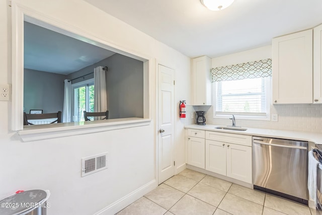 65 Cedar Ave Unit C10, Long Branch, NJ 07740 - kitchen with stainless steel dishwasher, light countertops, tasteful backsplash, light tile patterned flooring, and white cabinets