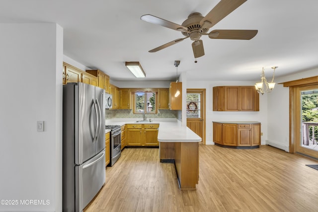 211 Meadow Blvd, Brick, NJ 08723 - kitchen featuring stainless steel appliances, light countertops, tasteful backsplash, light wood-style floors, and brown cabinets