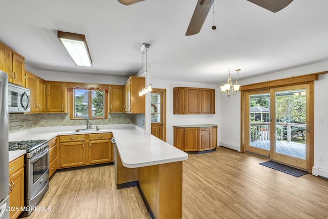 211 Meadow Blvd, Brick, NJ 08723 - kitchen with a peninsula, light countertops, light wood-style floors, stainless steel appliances, and decorative backsplash
