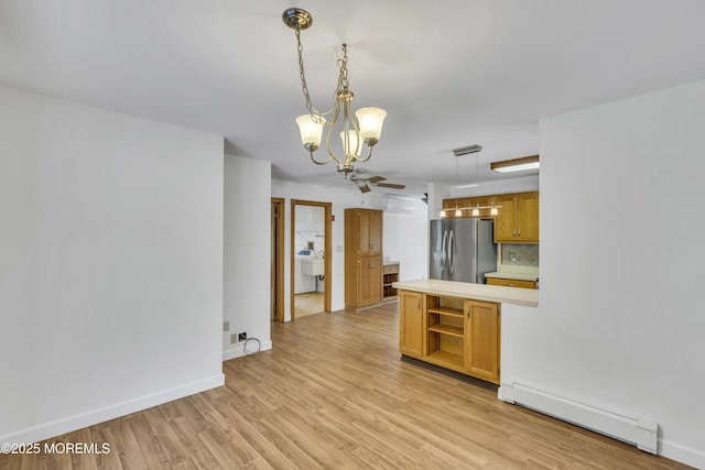 211 Meadow Blvd, Brick, NJ 08723 - kitchen with a baseboard radiator, light countertops, a chandelier, freestanding refrigerator, and tasteful backsplash