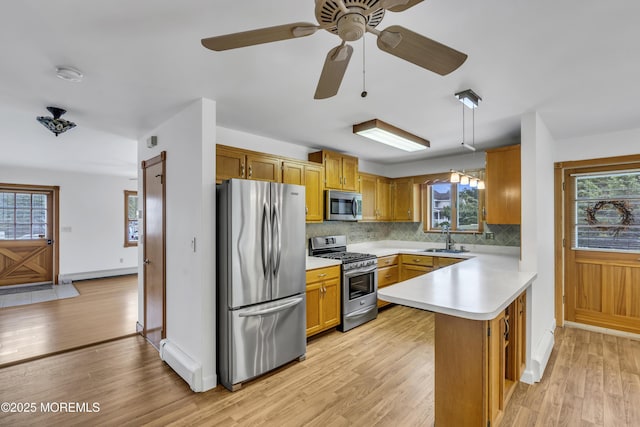 211 Meadow Blvd, Brick, NJ 08723 - kitchen with stainless steel appliances, a peninsula, light countertops, tasteful backsplash, and light wood-style flooring