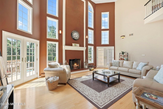 9 Old Cider Mill Rd, Manalapan, NJ 07726 - living room with a towering ceiling, wood-type flooring, french doors, and a large fireplace
