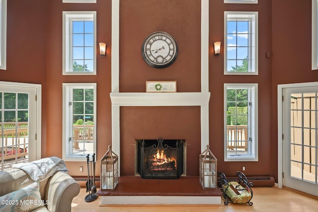 9 Old Cider Mill Rd, Manalapan, NJ 07726 - living area with a high ceiling, a lit fireplace, healthy amount of natural light, and wood finished floors
