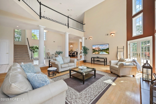 9 Old Cider Mill Rd, Manalapan, NJ 07726 - living room with ornate columns, a towering ceiling, light wood-style floors, and healthy amount of natural light