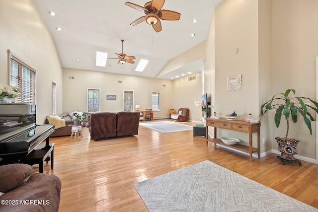9 Old Cider Mill Rd, Manalapan, NJ 07726 - living room featuring ceiling fan, a skylight, high vaulted ceiling, and light wood-style floors