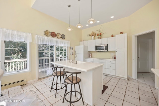 9 Old Cider Mill Rd, Manalapan, NJ 07726 - kitchen with stainless steel microwave, freestanding refrigerator, light tile patterned flooring, baseboard heating, and light countertops