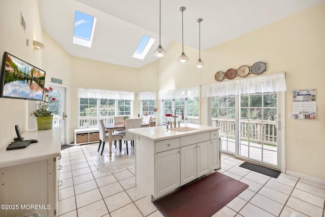 9 Old Cider Mill Rd, Manalapan, NJ 07726 - kitchen with a skylight, light tile patterned floors, light countertops, high vaulted ceiling, and hanging light fixtures