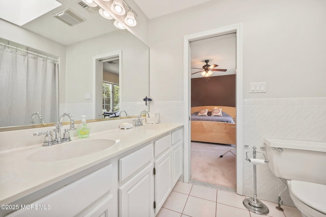 9 Old Cider Mill Rd, Manalapan, NJ 07726 - full bath featuring tile patterned floors, tile walls, double vanity, ensuite bath, and a wainscoted wall