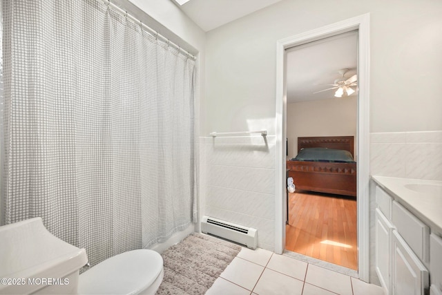 9 Old Cider Mill Rd, Manalapan, NJ 07726 - ensuite bathroom featuring a baseboard radiator, tile walls, vanity, tile patterned flooring, and a ceiling fan