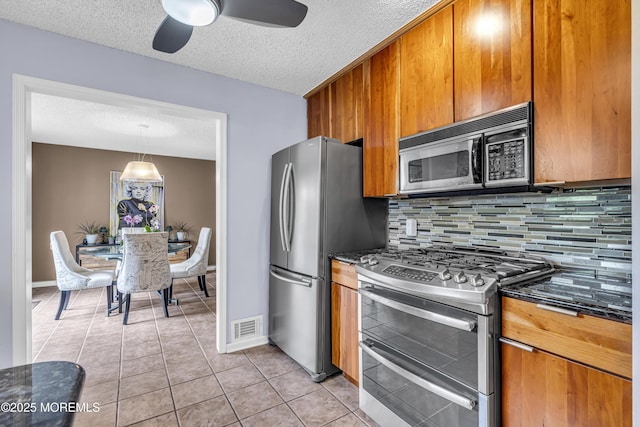 707 Cambridge Rd, Lanoka Harbor, NJ 08734 - kitchen with stainless steel appliances, brown cabinetry, a textured ceiling, decorative backsplash, and a ceiling fan