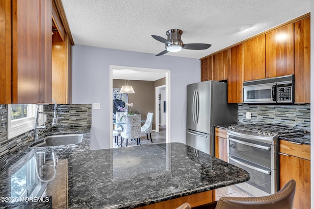 707 Cambridge Rd, Lanoka Harbor, NJ 08734 - kitchen with stainless steel appliances, a peninsula, brown cabinets, backsplash, and ceiling fan