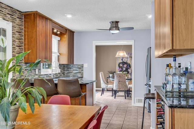 707 Cambridge Rd, Lanoka Harbor, NJ 08734 - kitchen with decorative backsplash, ceiling fan, light tile patterned flooring, a textured ceiling, and brown cabinetry