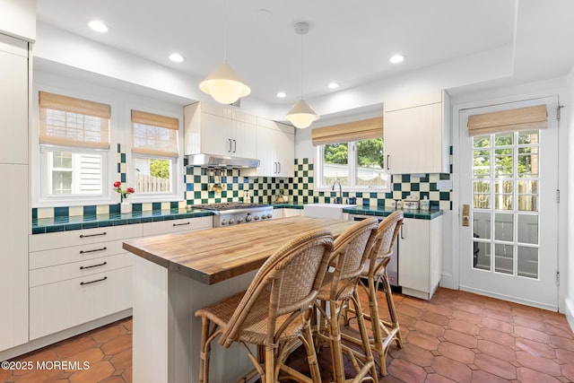 312 Lake Dr, Allenhurst, NJ 07711 - kitchen featuring butcher block counters, healthy amount of natural light, white cabinets, decorative backsplash, and recessed lighting