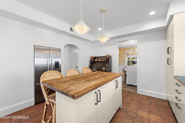 312 Lake Dr, Allenhurst, NJ 07711 - kitchen with stainless steel built in refrigerator, butcher block counters, a kitchen breakfast bar, white cabinets, and recessed lighting