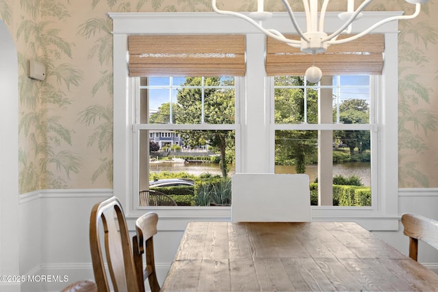 312 Lake Dr, Allenhurst, NJ 07711 - unfurnished dining area featuring wallpapered walls, a chandelier, a water view, and wainscoting