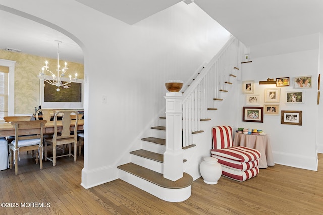 312 Lake Dr, Allenhurst, NJ 07711 - staircase with hardwood / wood-style flooring, arched walkways, and a chandelier