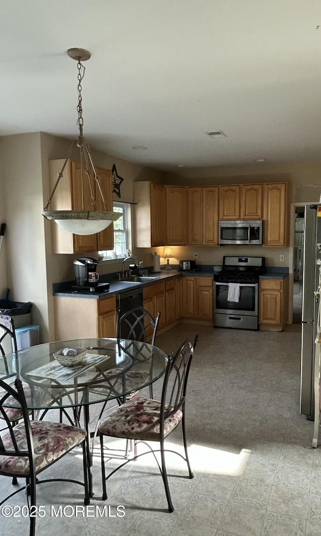 16 Aarons Way, Brick, NJ 08723 - kitchen featuring appliances with stainless steel finishes, dark countertops, decorative light fixtures, and brown cabinets