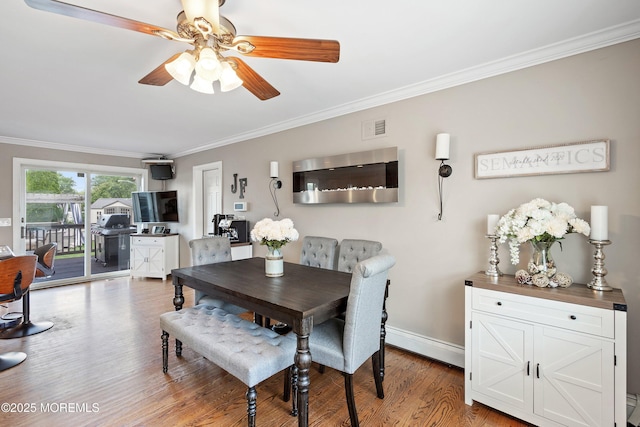 1020 Sarasota Dr, Forked River, NJ 08731 - dining area featuring ornamental molding, a baseboard radiator, ceiling fan, and light wood-style flooring