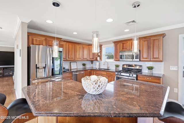 1020 Sarasota Dr, Forked River, NJ 08731 - kitchen with stainless steel appliances, ornamental molding, a breakfast bar, brown cabinets, and a large island