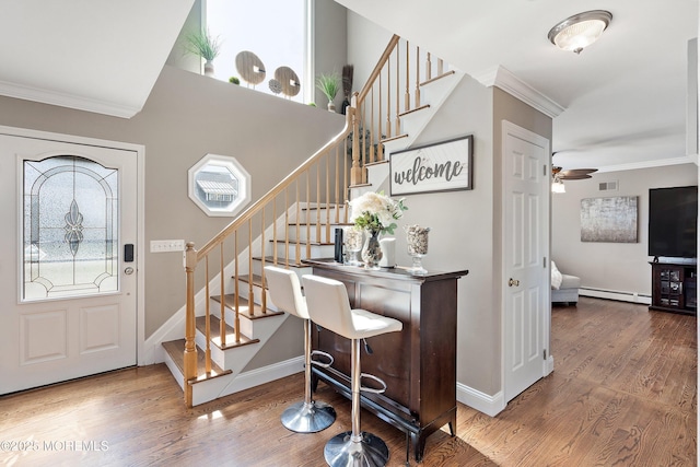 1020 Sarasota Dr, Forked River, NJ 08731 - foyer featuring ornamental molding, wood finished floors, stairway, and a baseboard heating unit