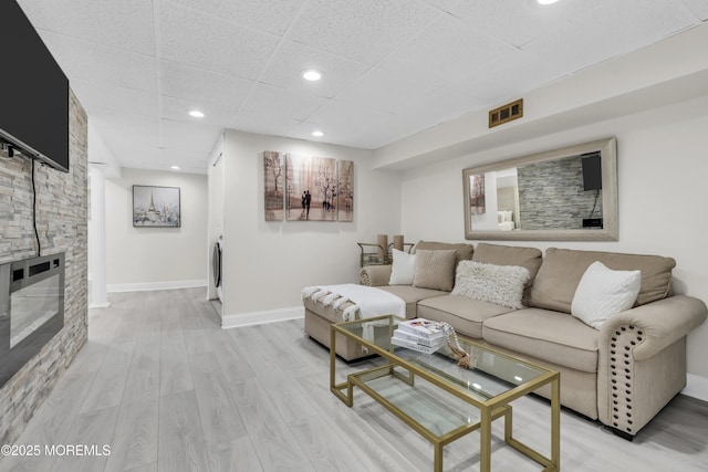 64 Scarlet Dr, Parlin, NJ 08859 - living area featuring light wood finished floors, washer / dryer, recessed lighting, a paneled ceiling, and a stone fireplace