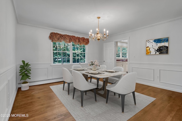 147 Montrose Rd, Colts Neck, NJ 07722 - dining space with a baseboard radiator, a chandelier, crown molding, wainscoting, and a decorative wall