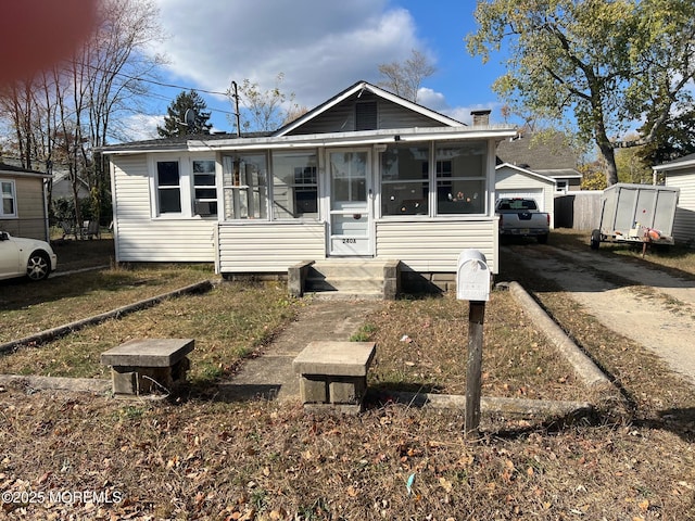 240 Beachwood Blvd, Beachwood, NJ 08722 - view of front of home with a sunroom, a detached garage, and an outbuilding